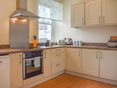 a kitchen with white cabinets and a stove top oven at Cumberland Place in Keswick