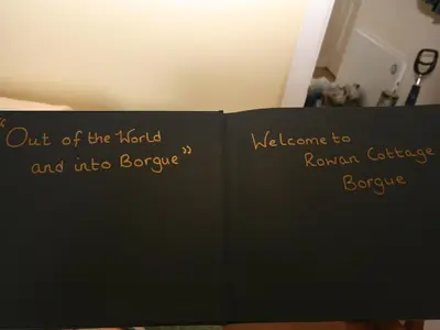 a book with the words out of the world and into everyone at Rowan Cottage in Borgue