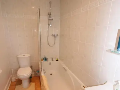 a bathroom with a tub and a toilet and a shower at Rowan Cottage in Borgue