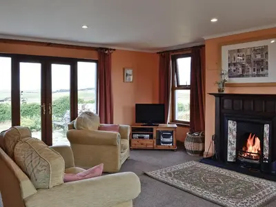 a living room with a fireplace and a tv at Allanhead in Borgue