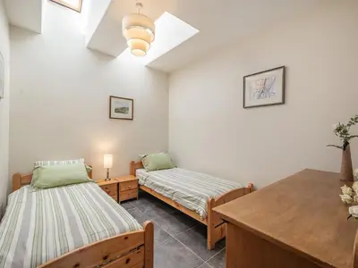 a room with two beds and a table in it at Strathmaddie Farm Cottage in Palnure