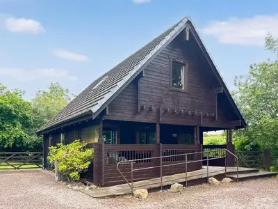 a log cabin with a gambrel roof at Criffel Lodge in Ringford