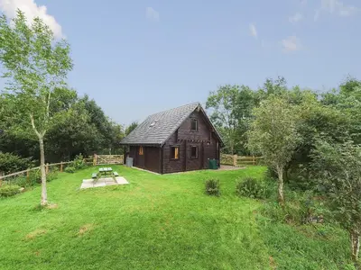 a barn in a field with a picnic table in front of it at Criffel Lodge in Ringford