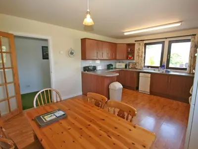 a kitchen and dining room with a wooden table at Rocky Knowe in Dalbeattie