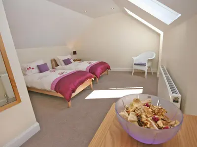 a bedroom with two beds and a bowl of food at Cairndoon Steading Whithorn in Carleton