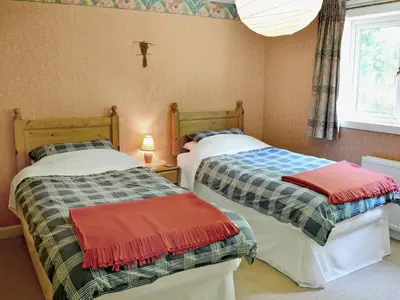 two beds sitting next to each other in a room at Squirrel Cottage in Palnure