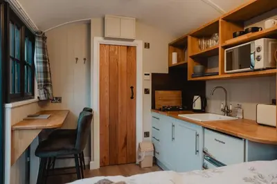 a small kitchen with a sink and a counter at Herdie Hideaway - Shepherds Hut in Wigton
