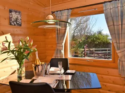 a dining room with a table and a window at Pheasant Lodge Scottish Borders in Carlisle
