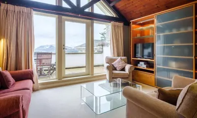 a living room with two chairs and a glass table at Underscar - Littledale in Keswick