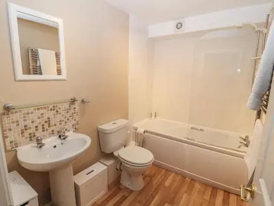 a bathroom with a toilet and a sink and a tub at Lillibet Cottage in Keswick
