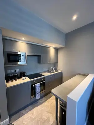 a kitchen with a sink and a stove top oven at The Globe Apartments and Bedrooms in Cockermouth