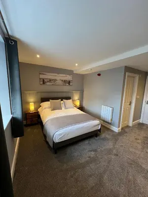 a bedroom with a large bed with two lamps on it at The Globe Apartments and Bedrooms in Cockermouth