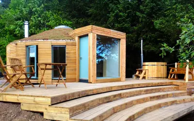 a cabin with a deck and a gazebo at Otter - Eco Bothy with Hot Tub in Castle Douglas