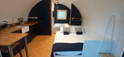 a bedroom with a bed and a desk and a sink at little peru luxury pods and alpaca farm in Crosshill