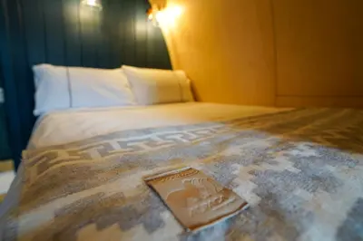 a bed with a blanket on top of it at Glencartholm Farm by Wigwam Holidays in Canonbie