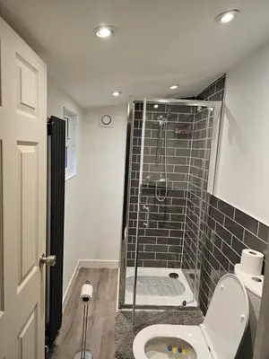 a bathroom with a toilet and a glass shower at Bridgepay Modern 4 bedroom House in Cumbria - Whitehaven - Free Parking in Whitehaven