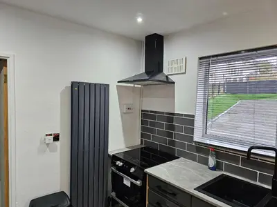 a kitchen with a black stove and a window at Bridgepay Modern 4 bedroom House in Cumbria - Whitehaven - Free Parking in Whitehaven