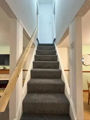 a staircase in a house with grey carpet at Bolton Terrace - 2 Bedrooms - Sleeps 4 in Workington