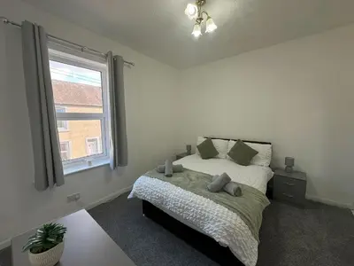 a bedroom with a bed and a window at Bolton Terrace - 2 Bedrooms - Sleeps 4 in Workington