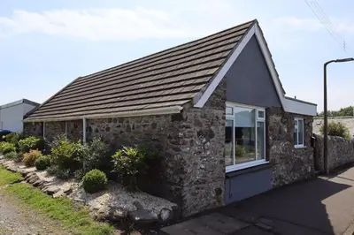 a small stone house with a pitched roof at Tigh Samhradh in Monreith