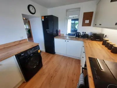 a kitchen with a washer and dryer in a room at Tigh Samhradh in Monreith