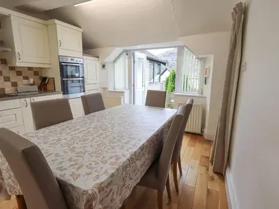 a kitchen with a table with chairs and a dining room at Hollens Cottage in Ambleside