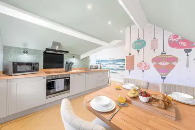 a kitchen with a wooden table and a dining room at Fell215 - Classic loft apartment at The Lairbeck in Keswick in Keswick
