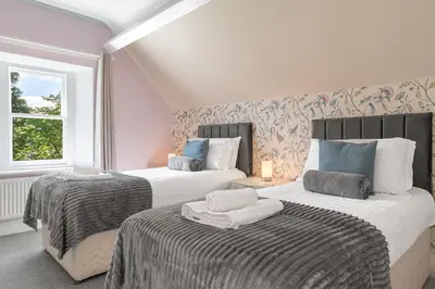 a bedroom with two beds and a window at Fell215 - Classic loft apartment at The Lairbeck in Keswick in Keswick