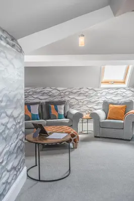 a living room with two couches and a table at Fell215 - Classic loft apartment at The Lairbeck in Keswick in Keswick