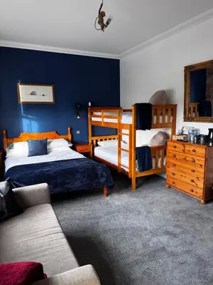 a bedroom with two bunk beds and a couch at Ecclefechan Hotel in Ecclefechan