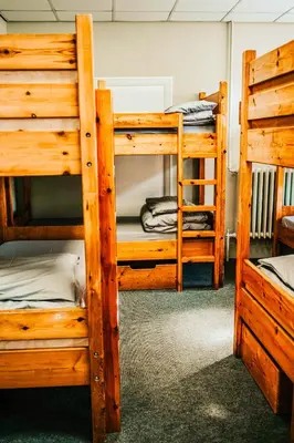 a room with three bunk beds in a cabin at Denton House Hostel in Keswick