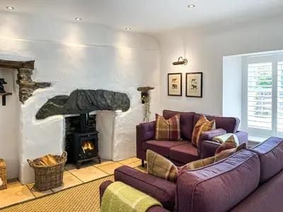 a living room with two couches and a fireplace at Bruce Cottage in Whithorn
