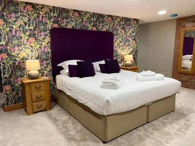 a bedroom with a large bed with towels on it at Blencathra Barn in Penrith