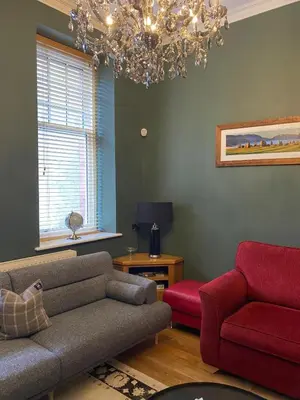 a living room with a couch and a red chair at Cumberland House in Cockermouth