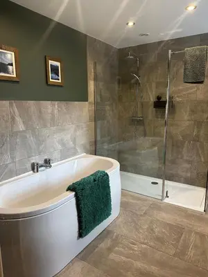 a bathroom with a tub and a glass shower at Cumberland House in Cockermouth