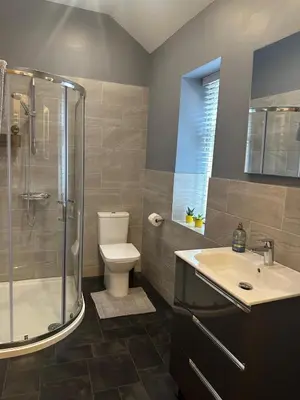 a bathroom with a shower and a toilet and a sink at Cumberland House in Cockermouth