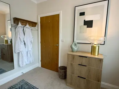 a bathroom with a door and a dresser and a mirror at The Guards Quarters - Uk47594 in Silloth