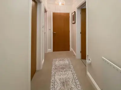 a hallway with a rug on the floor and a brown door at The Guards Quarters - Uk47594 in Silloth