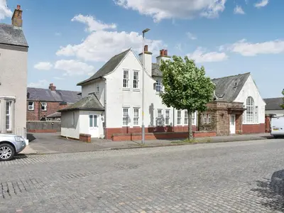 a white house on the side of a street at The Guards Quarters - Uk47594 in Silloth