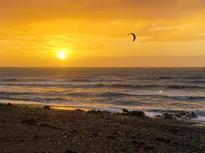 a person flying a kite on the beach at sunset at The Guards Quarters - Uk47594 in Silloth