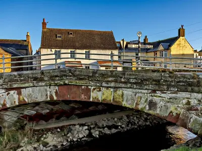 a bridge over a river with buildings in the background at 1 Bed in Allonby 95499 in Allonby