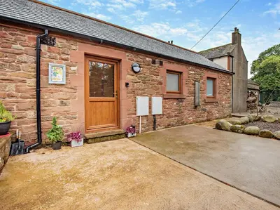 a brick building with a wooden door on it at 1 Bed in Allonby 95499 in Allonby