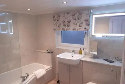 a bathroom with a sink and a bath tub at Burnbank Bed and Breakfast in Moffat