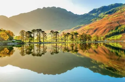 a lake with trees and mountains in the background at Tranquil House with Sea Views in Parton
