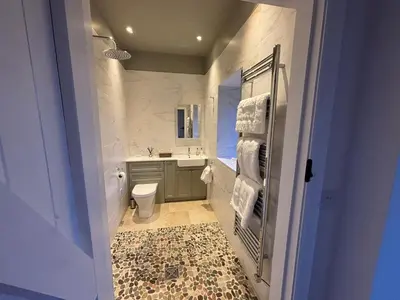 a bathroom with a sink and a toilet and a mirror at Stable Cottage in Lockerbie