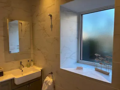 a bathroom with a window and a sink and a mirror at Stable Cottage in Lockerbie