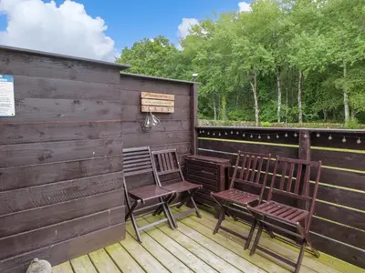 two chairs sitting on a deck with a fence at Glenisle in Dalbeattie