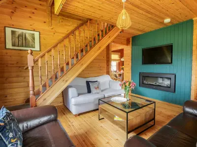 a living room with a white couch and a staircase at Glenisle in Dalbeattie