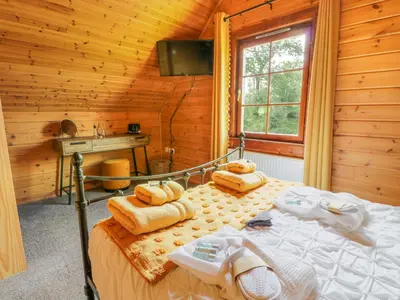 a bedroom with a bed in a wooden cabin at Glenisle in Dalbeattie