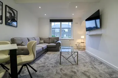 a living room with a couch and a table at Marchfield Promenade View in Prestwick